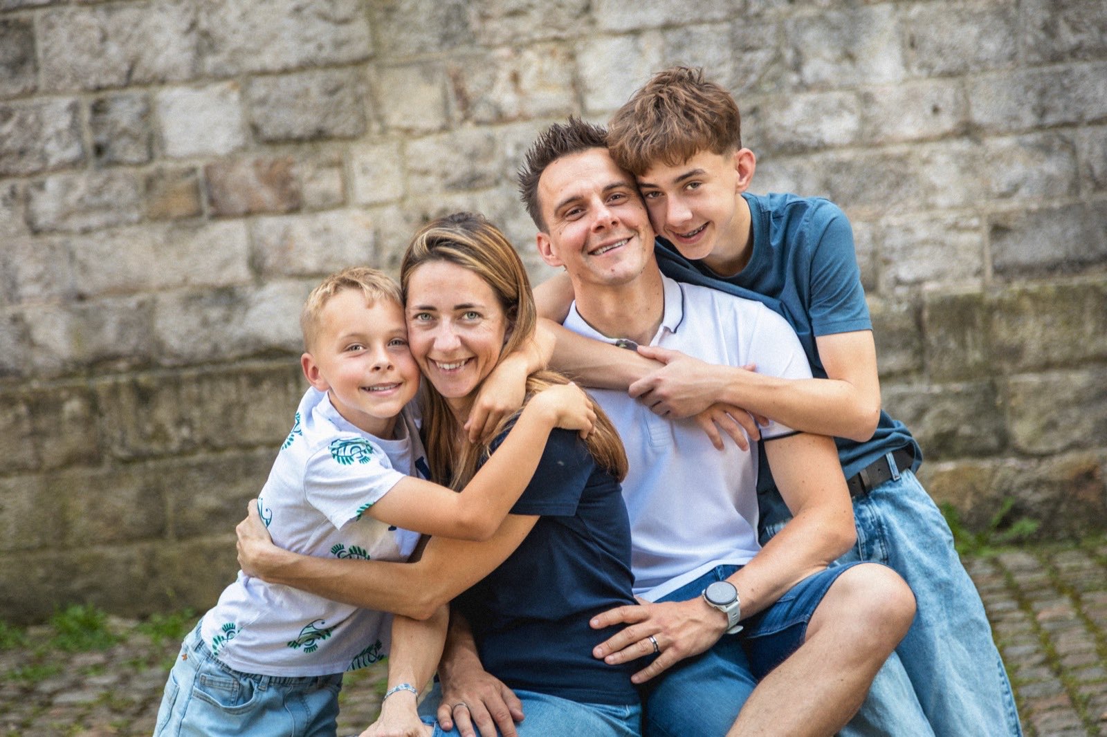 Famille enlacée lors d'une séance en extérieur