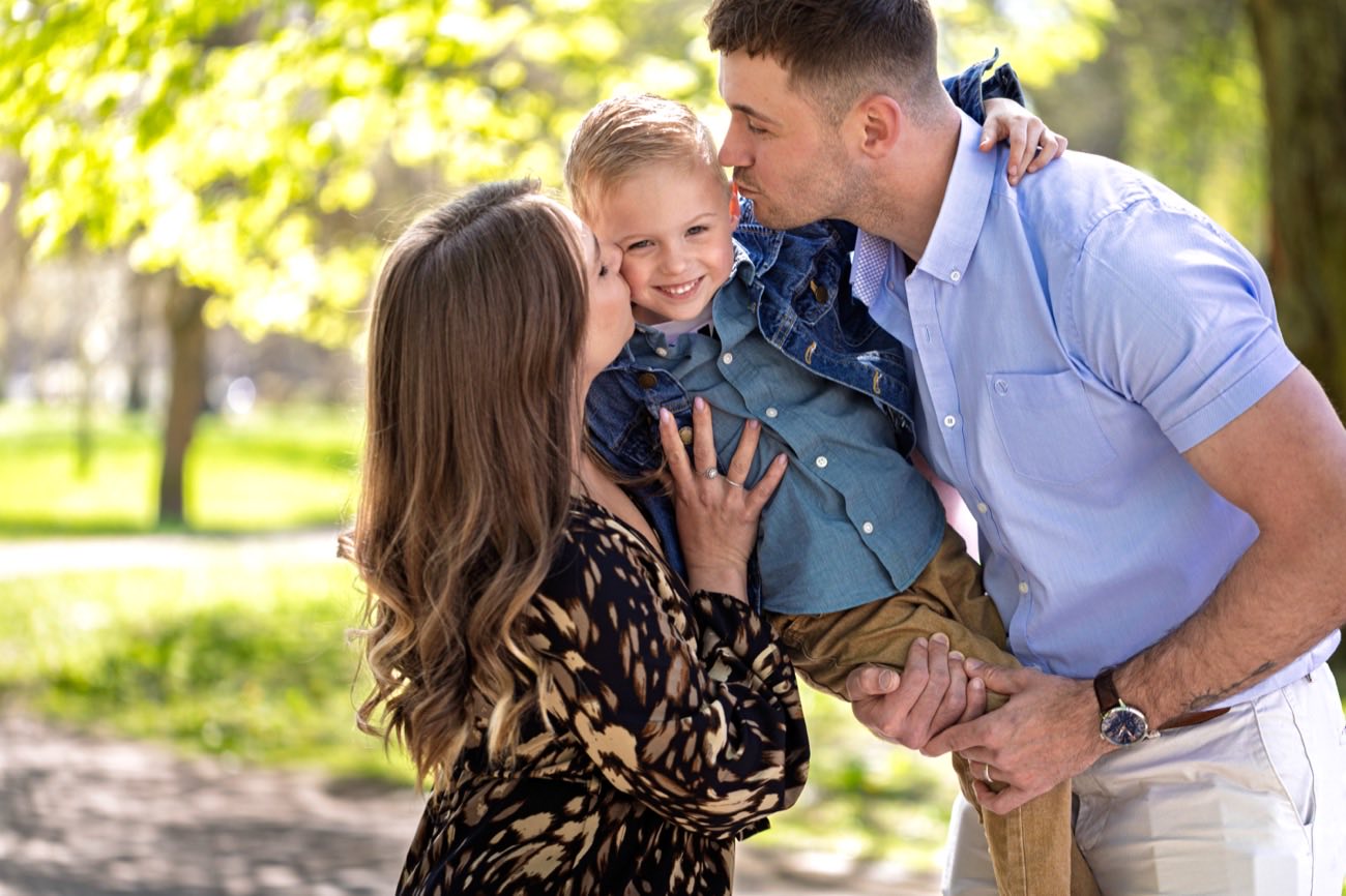 Parents embrassant leur enfant dans un park