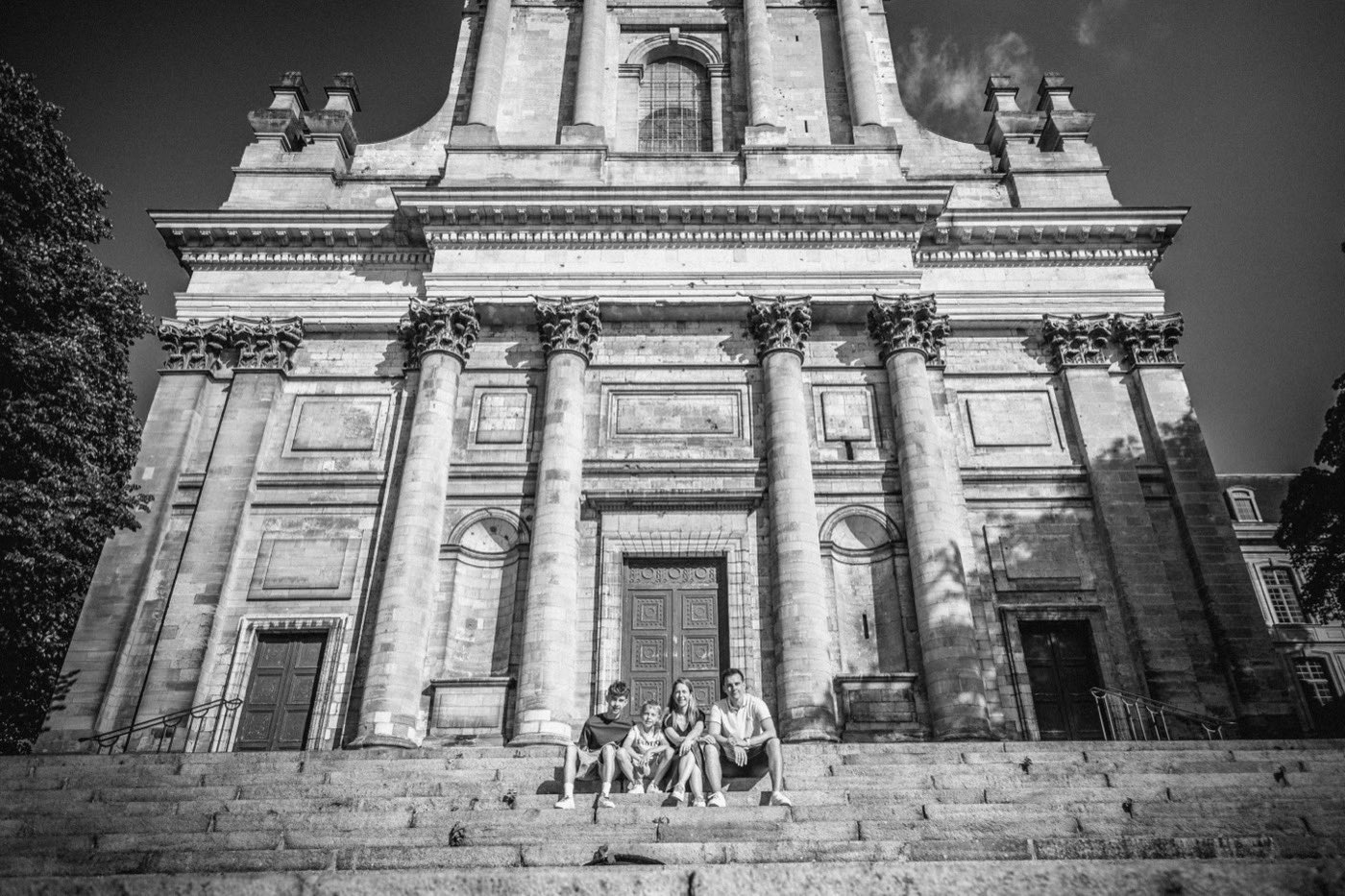 Famille riant sur des marches, noir et blanc
